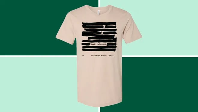 A Brooklyn Public Library Books Unbanned T-Shirt on dark and light green background.