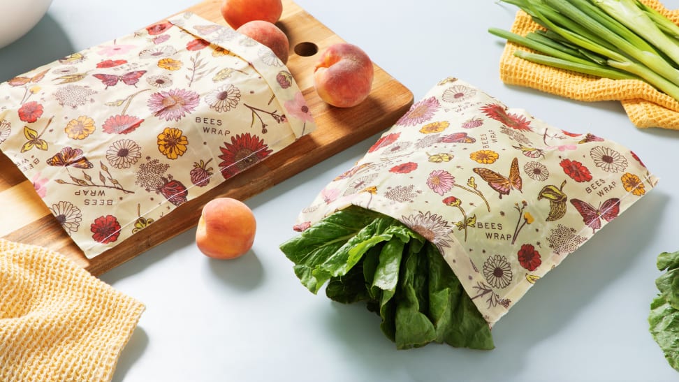 An assortment of peaches wrapped in a reusable produce bag next to a produce bag of lettuce.