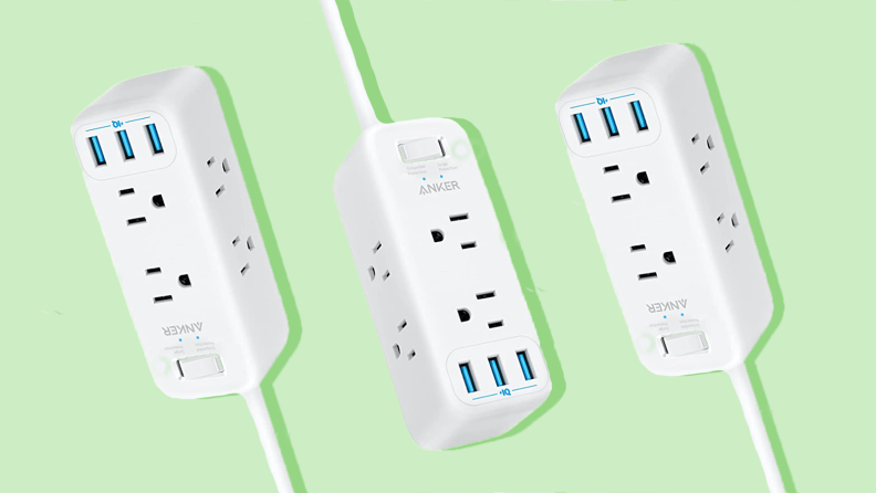 Three white surge protectors against a green background.
