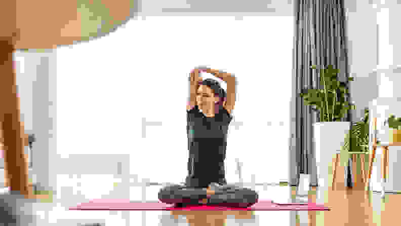 A woman practicing yoga at home.