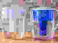 Two water pitchers against a brick wall