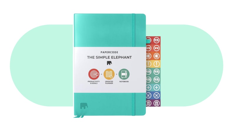 One of the best planners for ADHD, Papercode, with turquoise cover next to assorted colorful stickers.