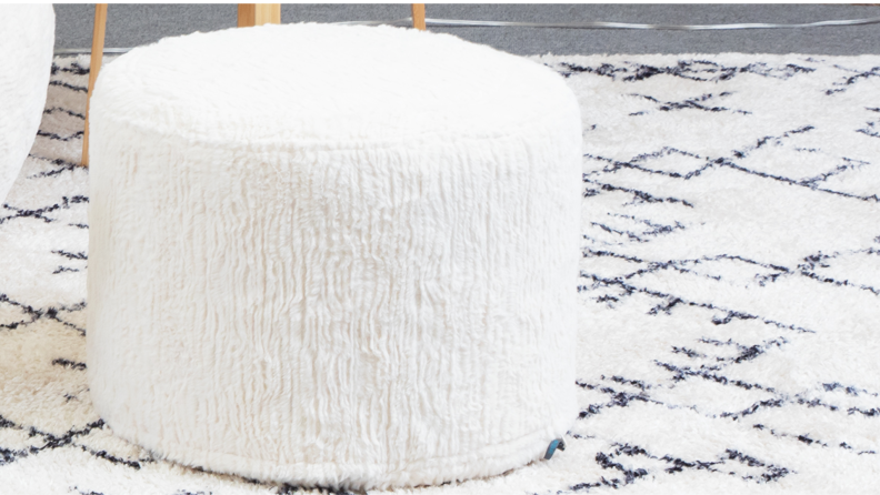 A close-up of Lovesac’s white furry ottoman.