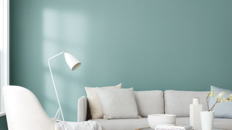 Mint blue wall next to all white couch and lamp