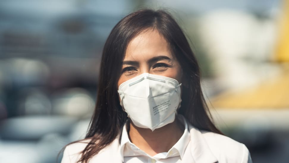 A woman with dark hair wearing an N95/KN95 mask