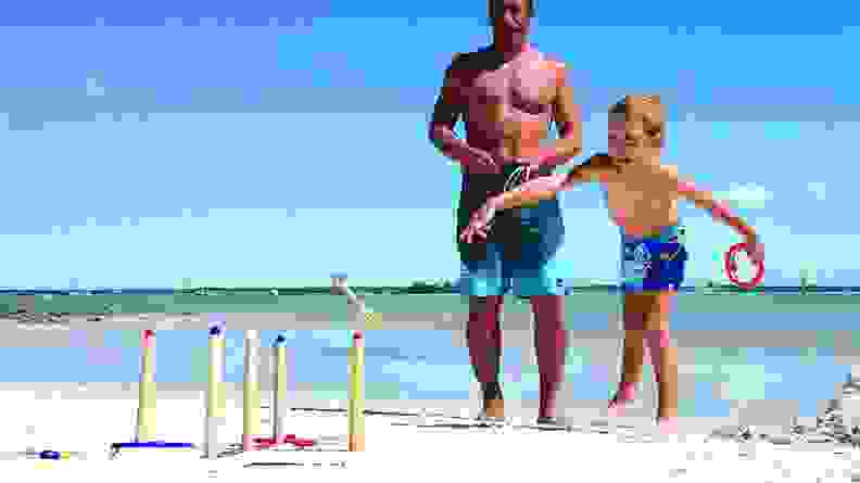People play ringtoss on a beach.