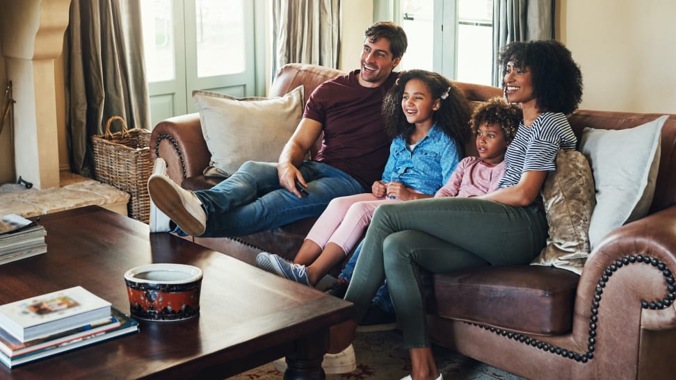 Family watching television together on a couch.