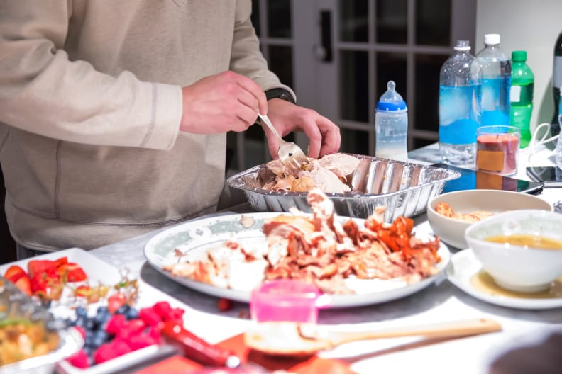 A man is putting away leftovers from a Thanksgiving day feast. RM