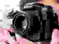 Close-up photo of a person using a Nikon DSLR camera.