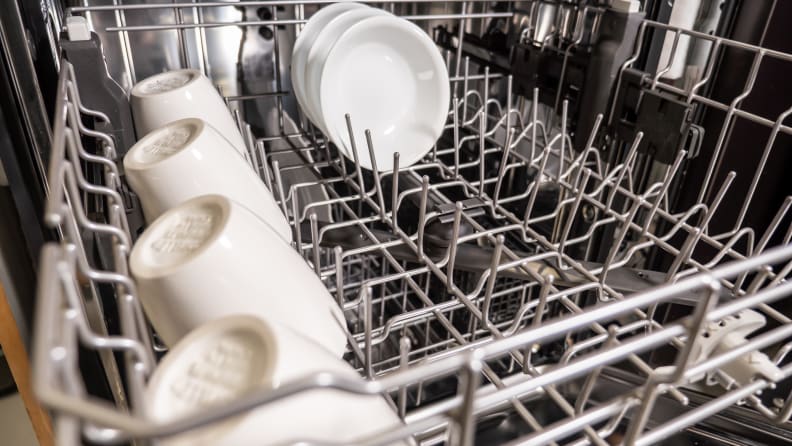 A close-up of the Whirlpool WDT750SAKZ dishwasher's upper rack, with rows of coffee cups stowed away along its left edge.