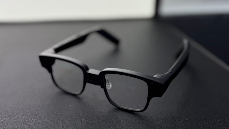 Techno's AI glasses sit on a black table, alone.
