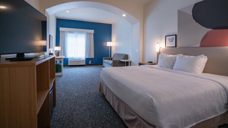 A contemporary Spark by Hilton guest room with a large bed and seating area, perfect for comfortable stays found through last-minute hotel deals.