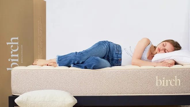 Birch Living mattress with a woman on top of it in a bedroom setup