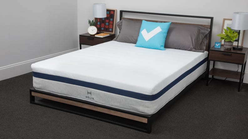 The Helix Midnight mattress appears in a bedroom with bedside tables on either side.