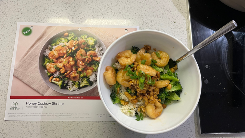 A bowl of shrimp and rice next to its Home Chef recipe card.