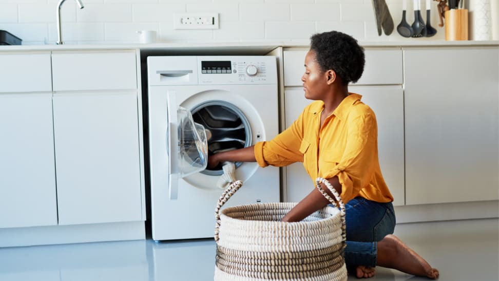 Woman doing laundry in her kitchen at home