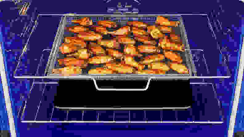 Some chicken wings being prepared inside the oven.