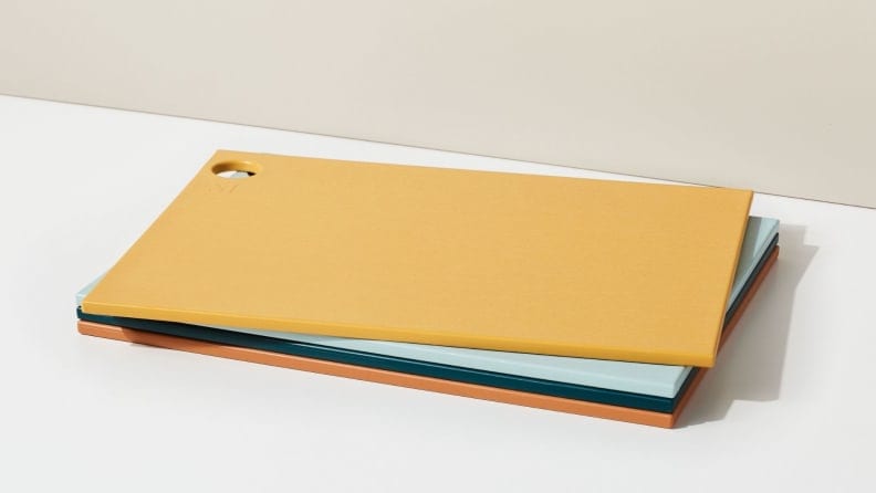 A stack of four colorful plastic cutting boards.