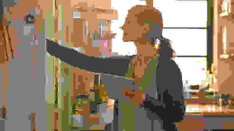 A woman inspects her fridge to make sure it's set up and ready for regular use.