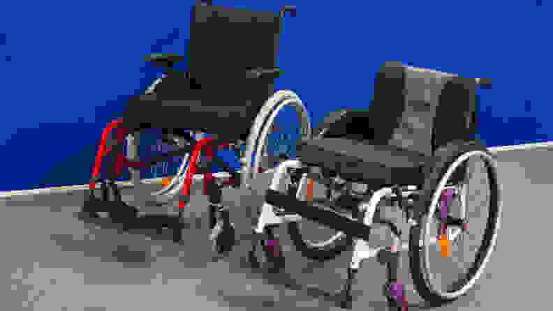 Two wheelchairs in front of a blue wall.