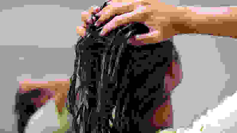A photo of a woman conditioning her hair.