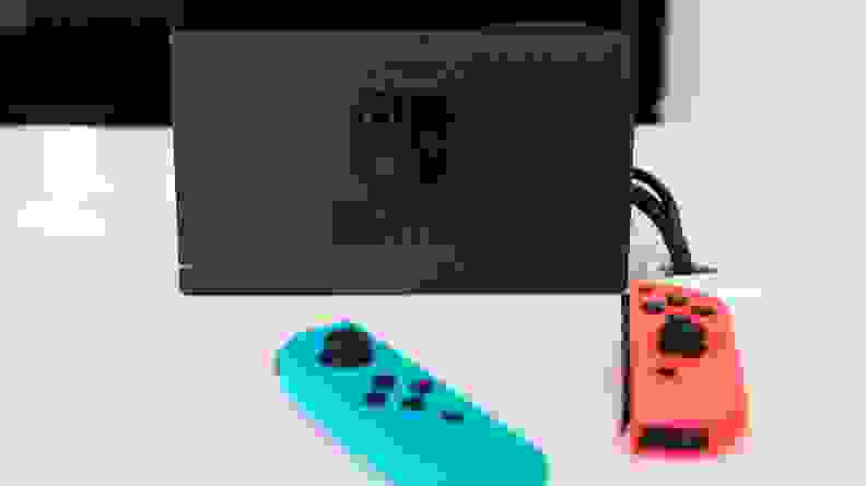 两个Nintendo Joycons和一个开关码头的图片