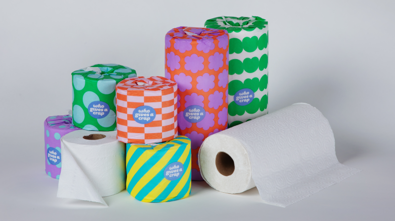 toilet paper and paper towels in colorful wrapping paper on white background