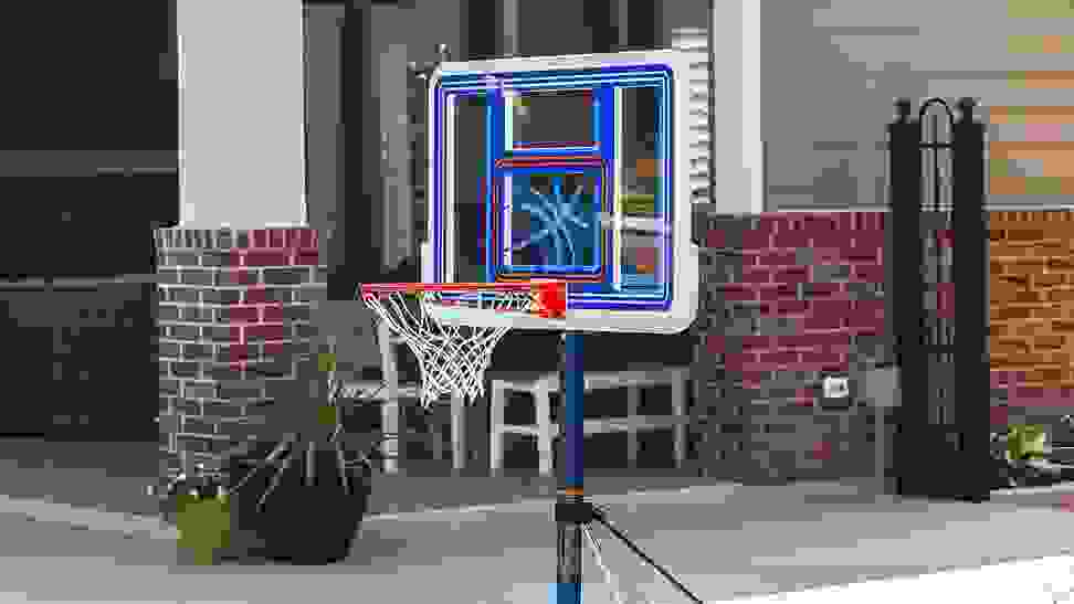 A basketball hoop set up over an in-ground pool.