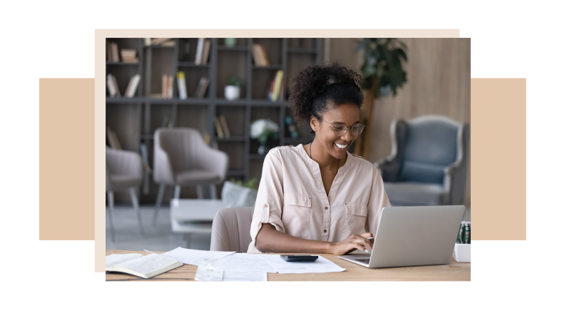 A person smiles as they search for a job using a laptop computer at home.