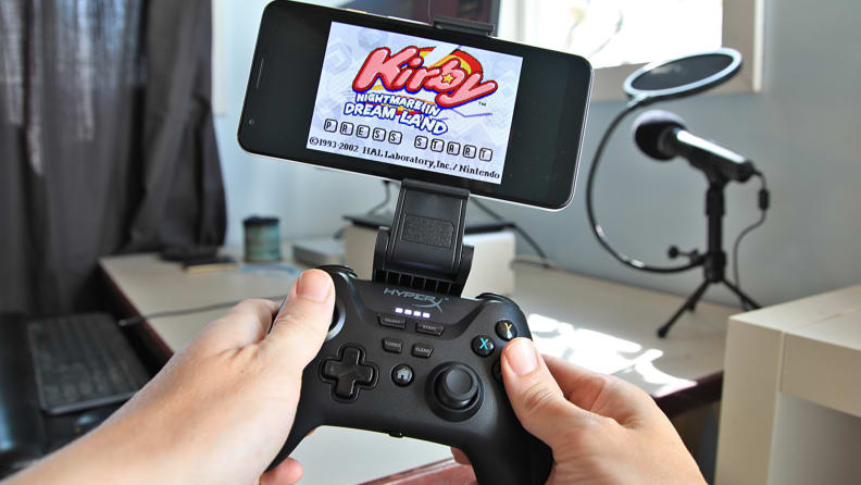 A person plays a video game with the HyperX Clutch game controller.