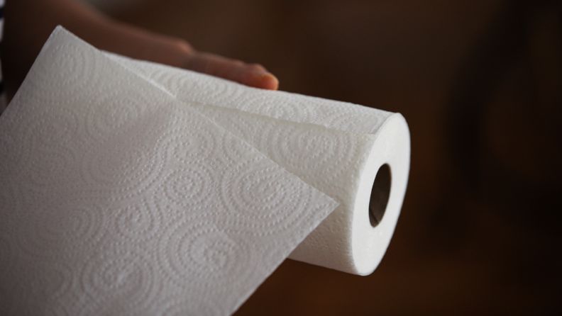 用手从纸卷上抽出一张纸巾。