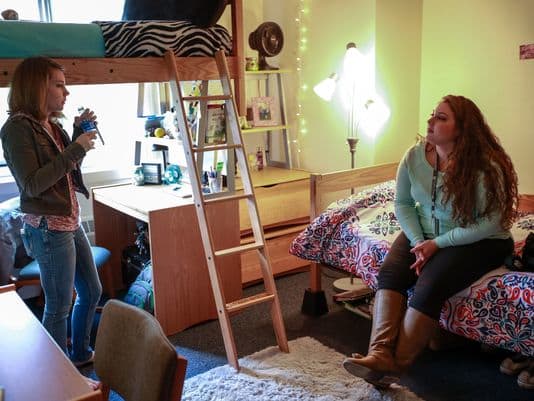 Mariah Whitelock, 18, of Riverview, right, a freshman at Oakland University in Rochester, chats with her roommate, Stephanie Campbell, 18, of Ortonville in their dorm room on Friday, Oct. 30, 2015.