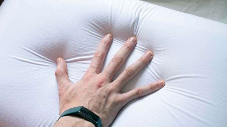 a hand presses into the Tempur-Cloud pillow surface