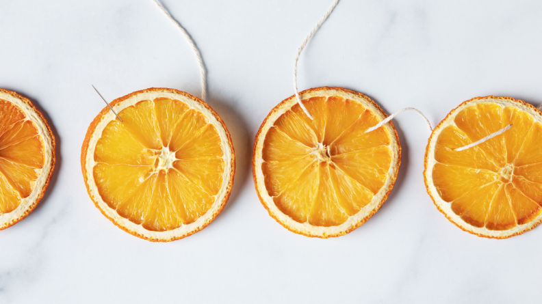 Dried oranges with a needle and twine strung through.