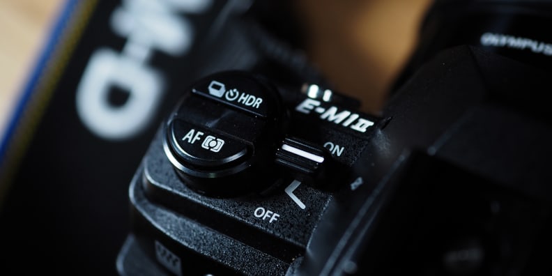 The Olympus OM-D E-M1 II features a pro-style drive and focus cluster on the top.