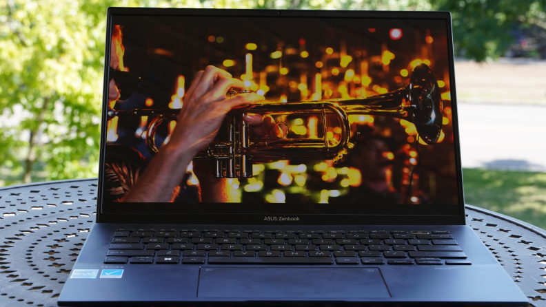 An Asus laptop computer sits on a patio table outside.