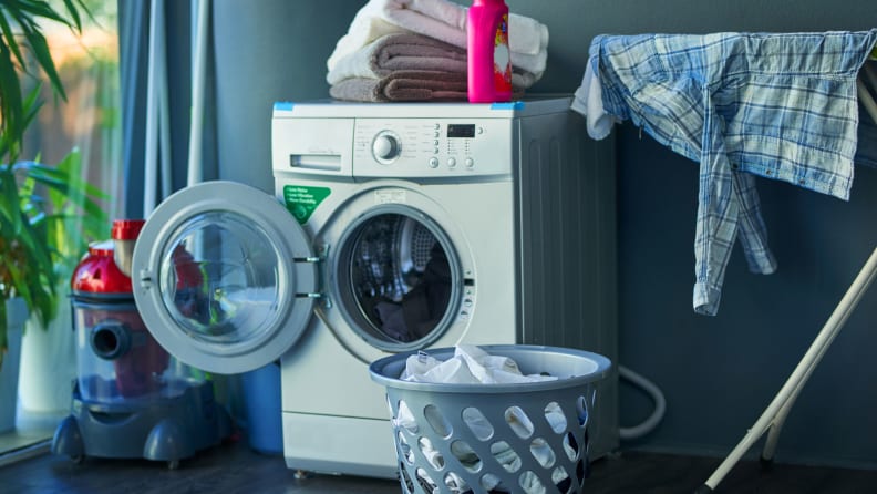 Una lavadora se encuentra en su cuarto de lavado, con la puerta abierta para secar.