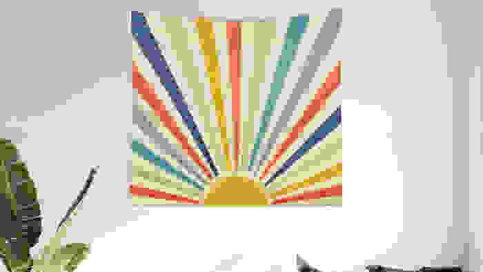 Tapestry with rainbow streaks coming from sun.