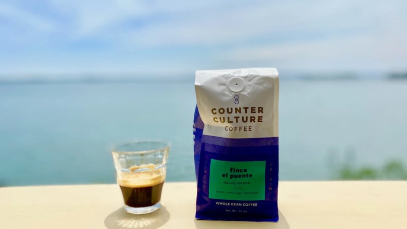 A cup of espresso next to a bag of Counter Culture Coffee beans