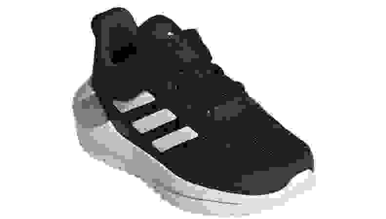 反对白色背景的黑adidas运动鞋。