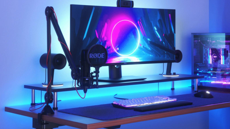 The Nanoleaf matter essentials light strip installed behind a computer monitor and illuminated in blue