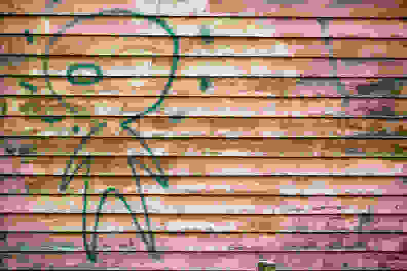 Alien graffiti on rich colored wooden wall.