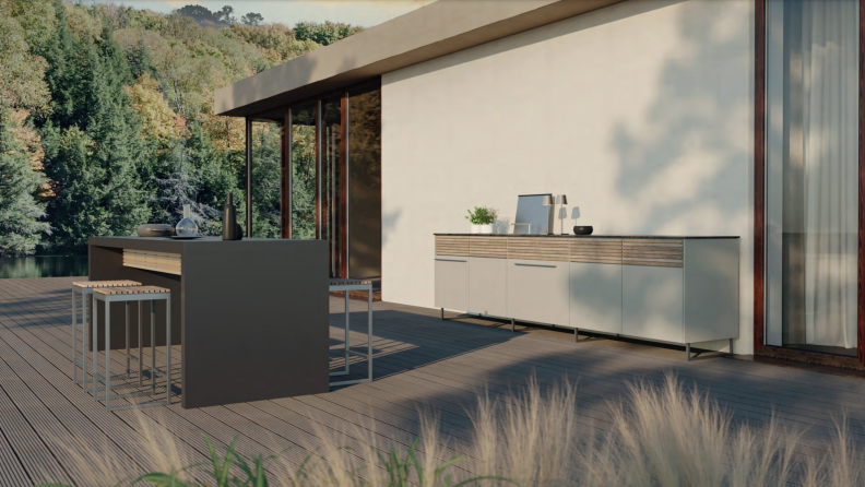 Angled outdoor view of the long, gray ceramic table of the Cubic Outdoor Living Kitchen in a Table on a minimalist patio.