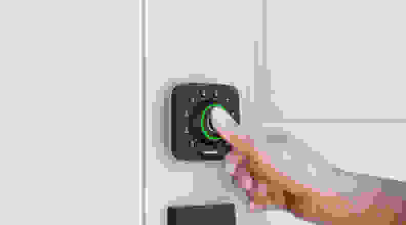 A person's hand pushing a button on a smart door lock
