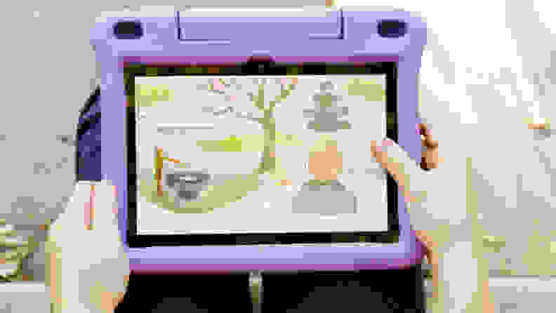 A child holding a kindle fire with a purple cover and an animation image on the screen.