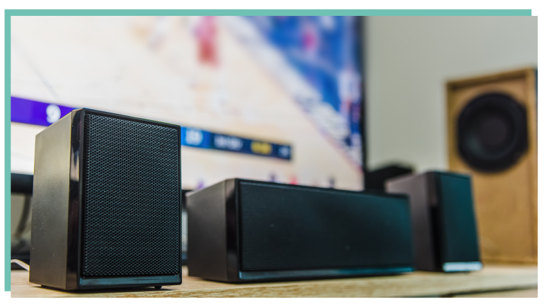 Three home theatre speakers in front of large flat screen television.