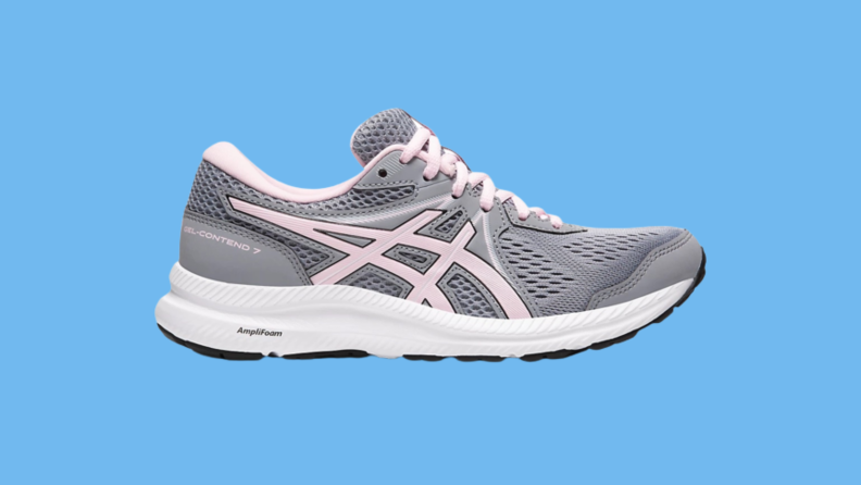 A gray and pink sneaker against a blue background.