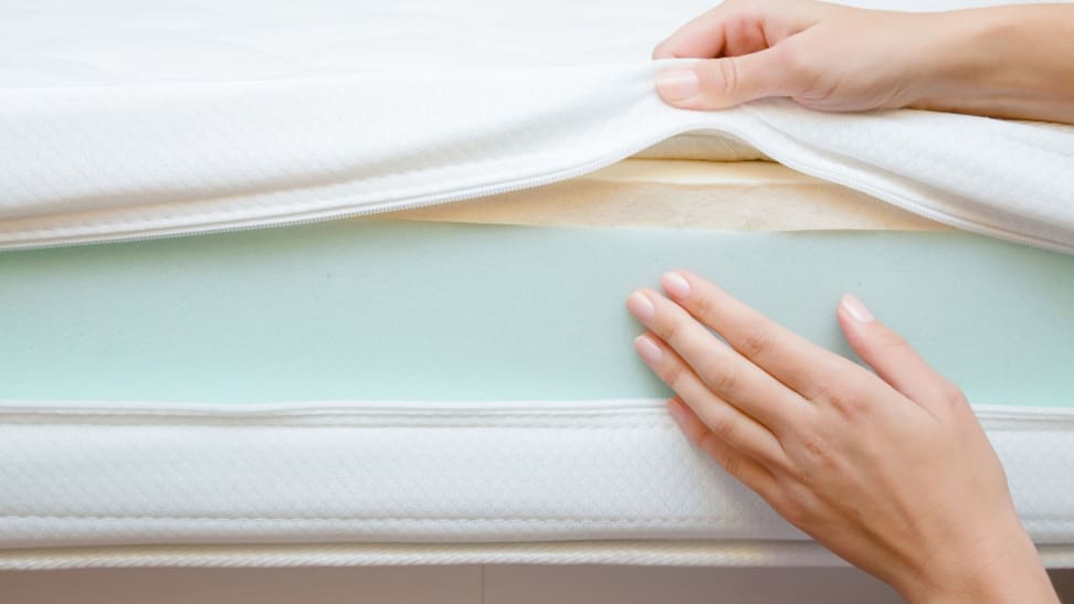 hands show the layers of a mattress