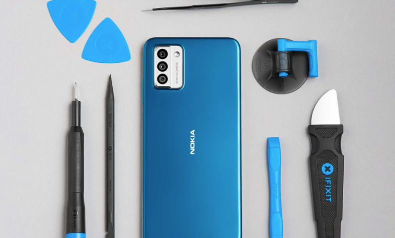 A blue Nokia phone sitting on a gray table with tools to replace its parts next to it.