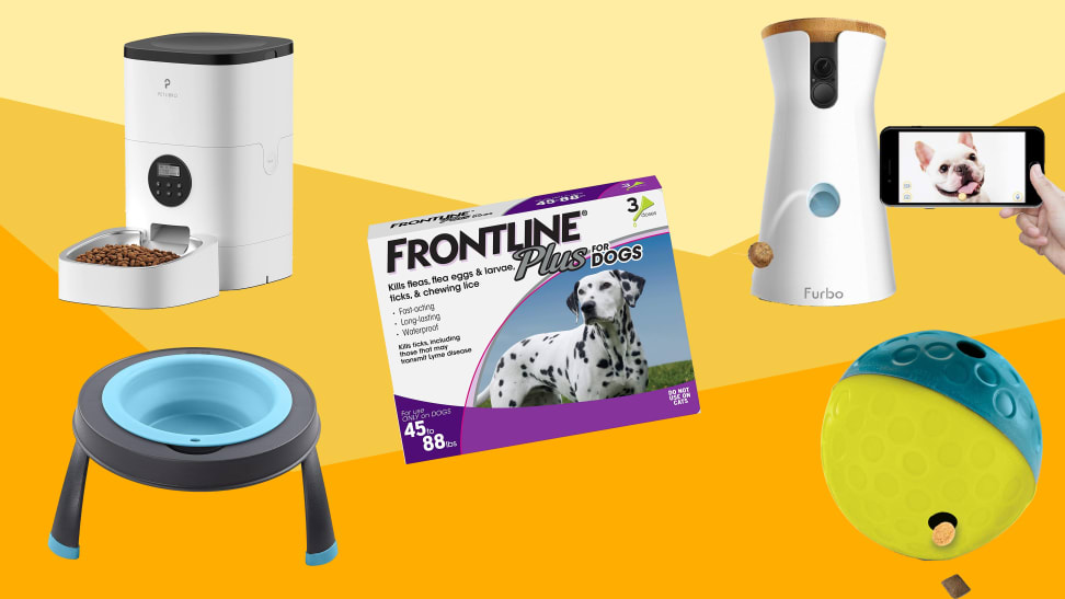 An automatic pet feeder, a box of Frontline Plus, a treat dispenser, a rubber toy, and a silicone bowl against a varied yellow background.